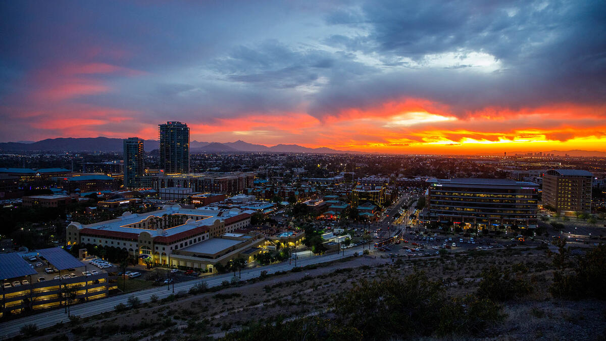 Skyline view of the city of Tempe with a colorful sunset in the background.