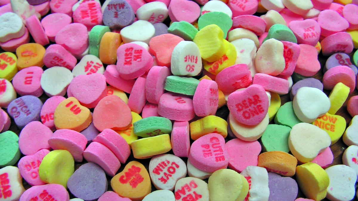 A pile of candy hearts with messages stamped on them.