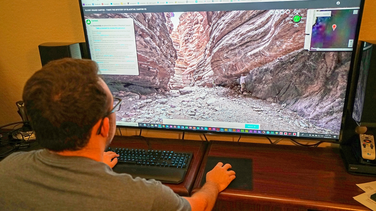 Man on computer exploring a canyon through a virtual field trip