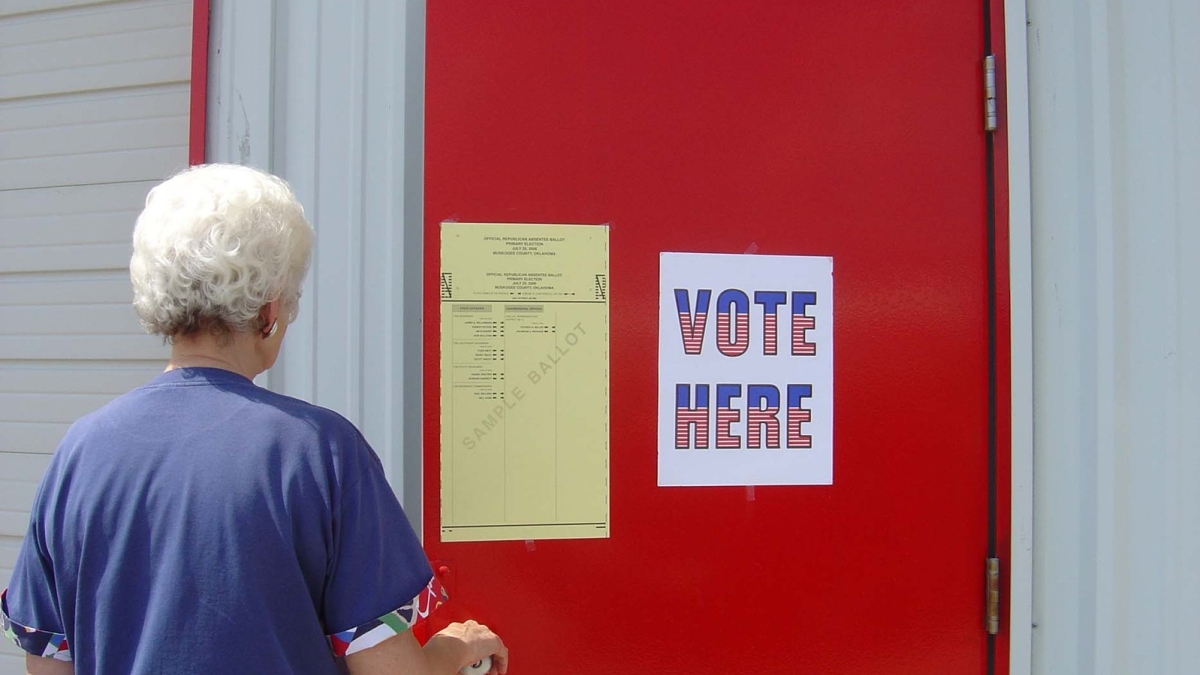 A woman opens a door to a voting location.
