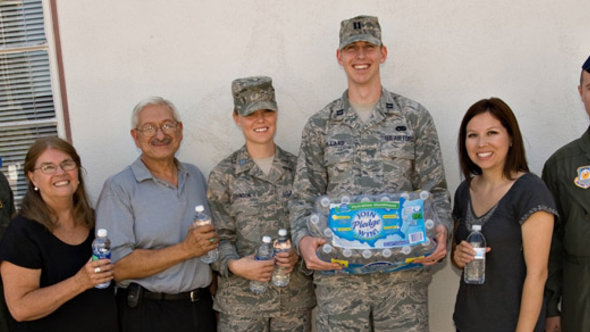 seven individuals donating bottles of water to Salvation Army