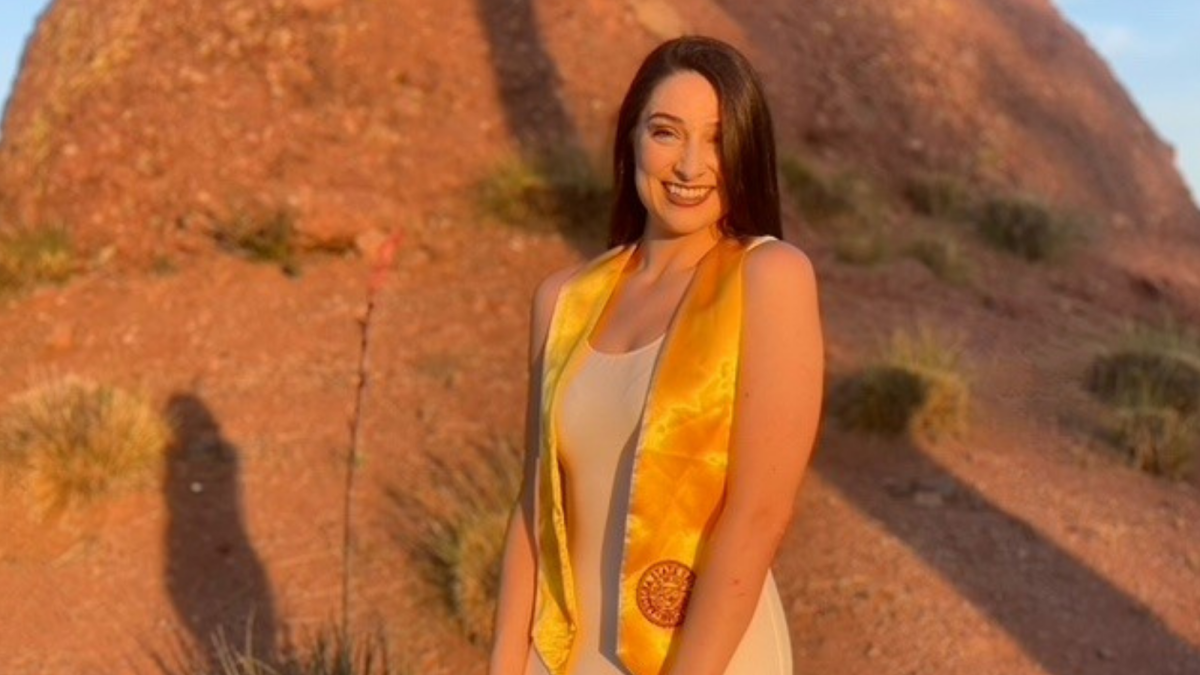 Edson College Outstanding Graduate Kaitlyn Weeks poses for graduation pictures wearing a gold graduation stole