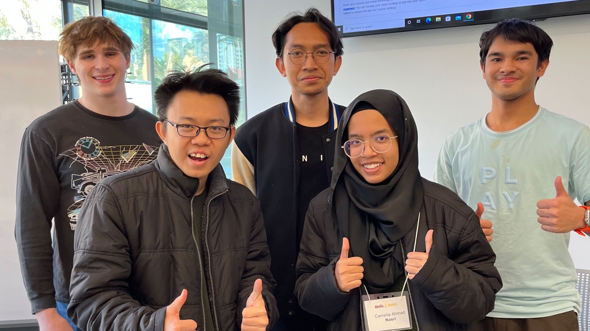 A group of five ASU computer engineering students smiling and making the thumbs up sign after winning hackathon.