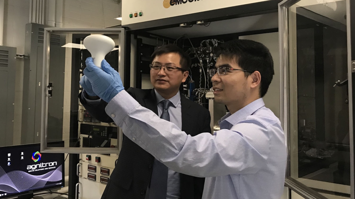 Yuji Zhao (left), an electrical engineering professor in Arizona State University’s Ira A. Fulton Schools of Engineering, and Houqiang Fu (right), a doctoral student in Zhao’s research group, hold an LED light bulb.