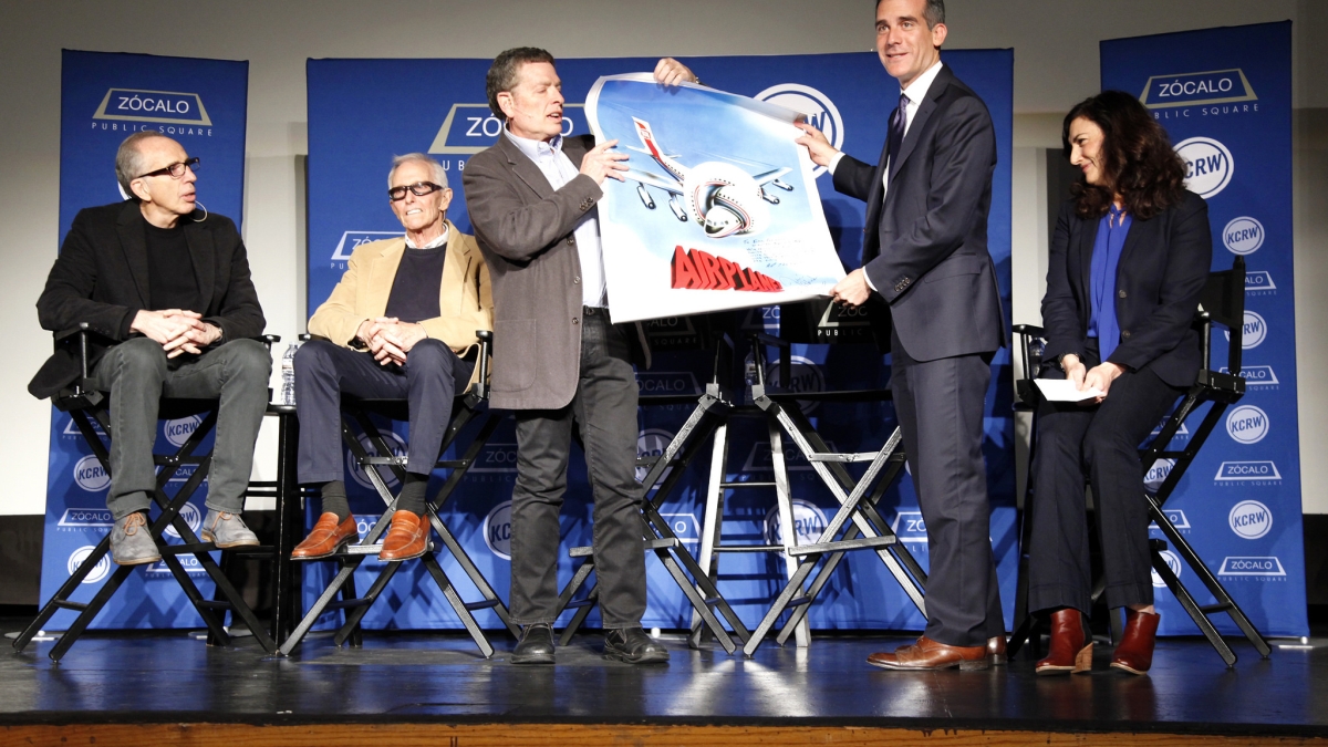man being presented with movie poster on stage