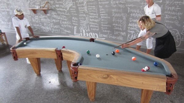 People playing on an irregular pool table.