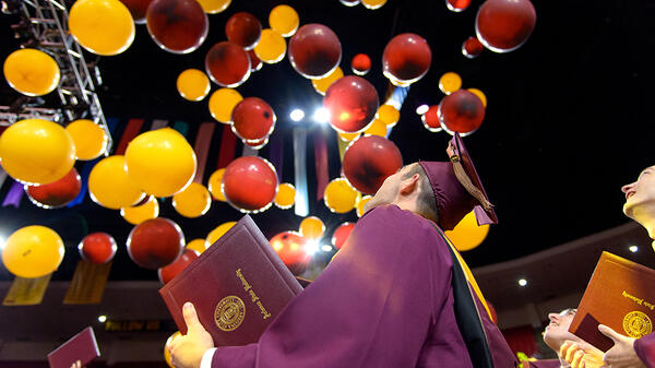student looking at balloons during commencement