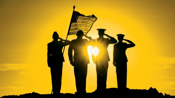 Four saluting military members are silhouetted against a setting sun