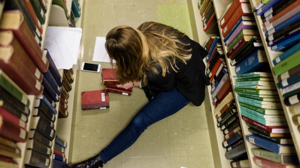 Then-doctoral student Emily Zarka combs through books from Hayden Library's stacks looking for traces of the books past "lives" in this 2017 photo from the ASU Book Traces project. Photo by Andy DeLisle/ASU.
