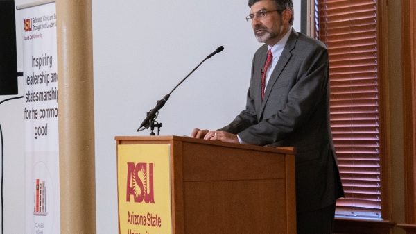 man standing and talking at a podium