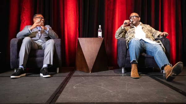 Two men sit onstage for a discussion about sports and diversity