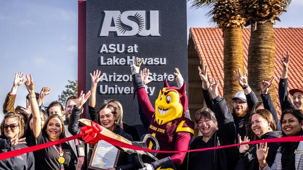 ASU mascot Sparky the Sun Devil and a crowd of people celebrate at a ribbon-cutting ceremony.