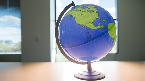A backlit globe sits on a table in front of a window