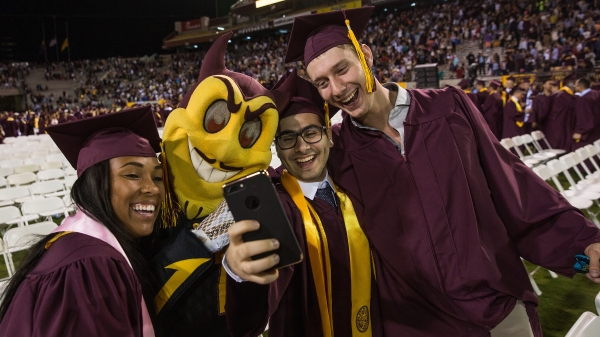 New ASU graduates pose with Sparky at commencement