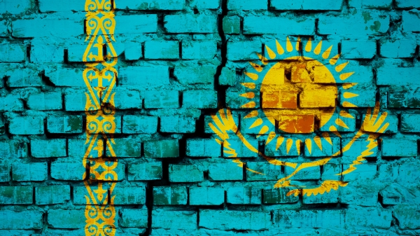 Painting of the flag of Kazakstan on a brick wall with a crack down the middle of it.