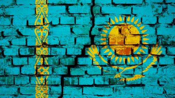 Painting of the flag of Kazakstan on a brick wall with a crack down the middle of it.