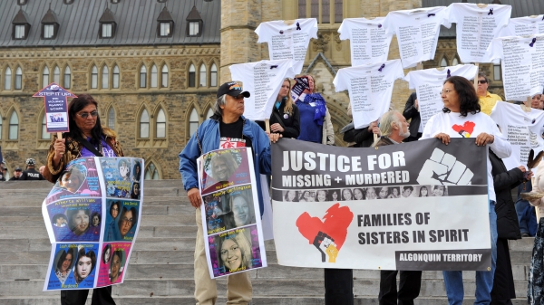Crowd holding signs demanding justice for missing and murdered Indigenous women.
