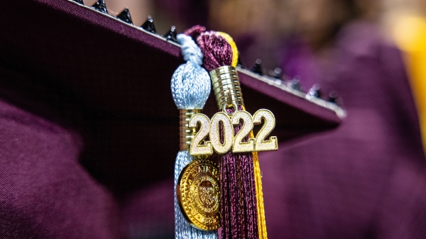 A closeup of a tassel hanging from a graduation cap with a 2022 charm