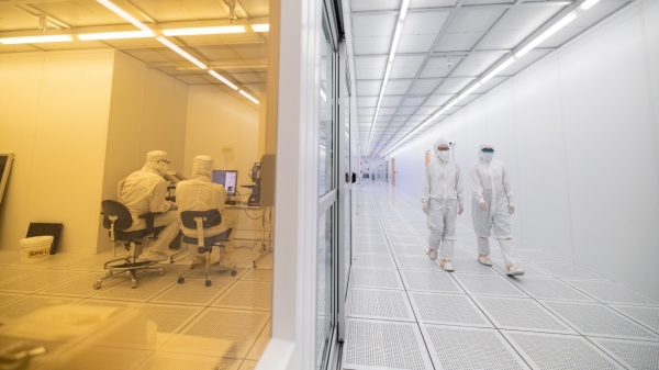 People working in a lab wearing clean suits