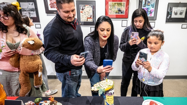 A family takes photos of art at an exhibit
