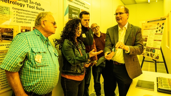 Man showing tour group sample from photolithography lab 
