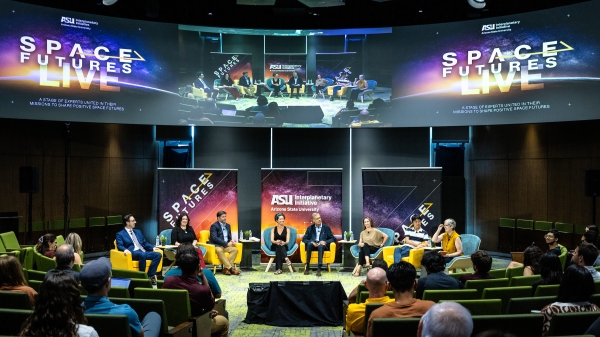 Group of people sitting on a stage for a panel discussion.