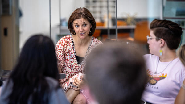 Woman talking with college students in a classroom