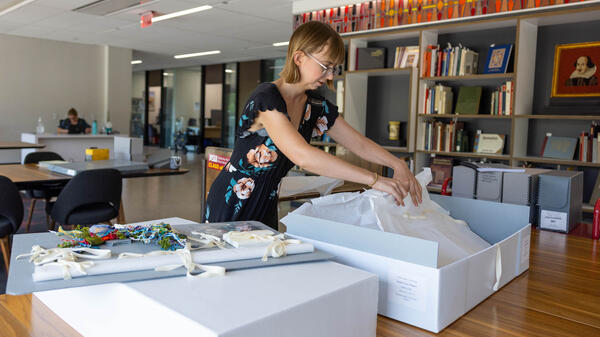 Woman handling collection materials in library.