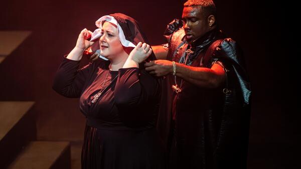 Two people dressed in religious costumes perform in contemporary opera