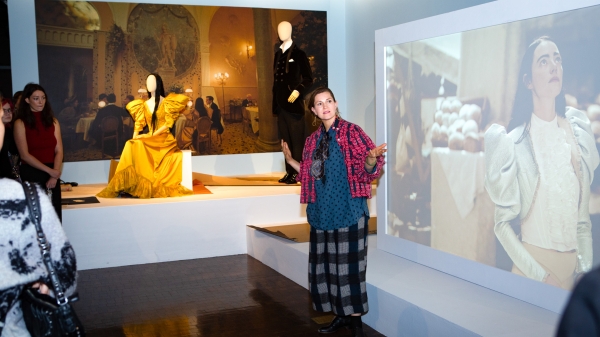 Woman explaining costume design at exhibition