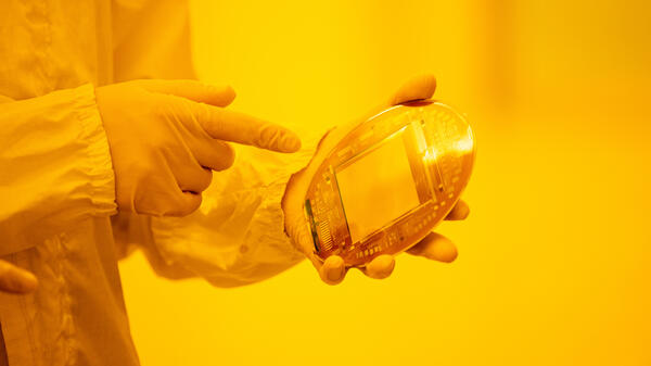Gloved hands holding a solar sample.