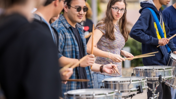 Lineup of students playing snare drums outside