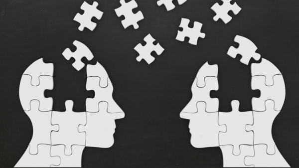 Illustrated image of two heads made up of puzzle pieces facing one another