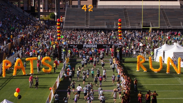 Football field set up for a race with balloons spelling "Pat's Run."