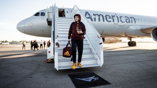 Football player disembarks from an airplane.