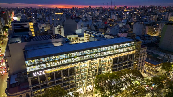 The UAED campus in Buenos Aires, Argentina, all lit up against a setting sun and lit-up city.