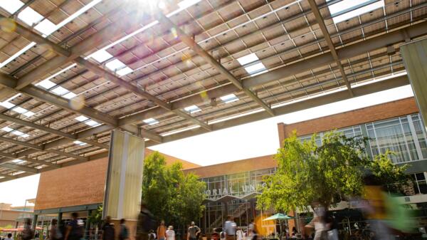 Sunlight shines through gaps in a solar awning over the plaza outside the ASU Memorial Union