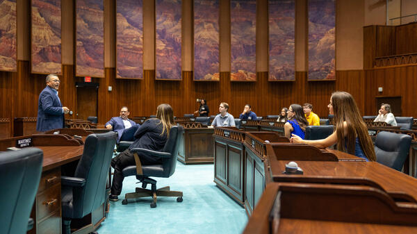 Professor speaking to students in a room used for diplomatic hearings.
