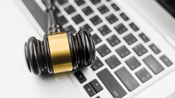 A gavel sits on top of a laptop. 
