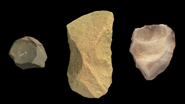 Three stone tools against a black background