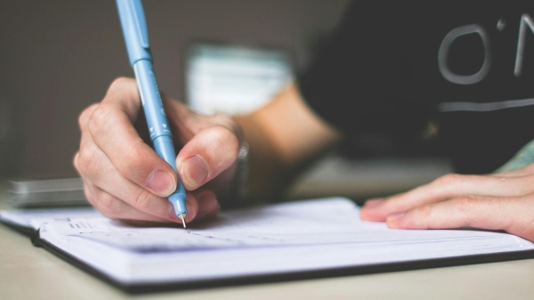 Person writing in notebook