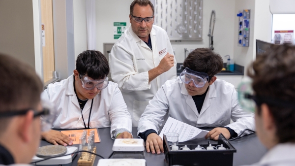 Professor and high school students conducting research in a lab