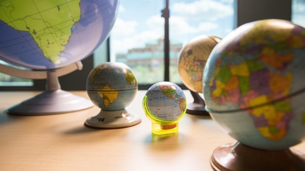 A handful of globes in various sizes sit on a tabletop.