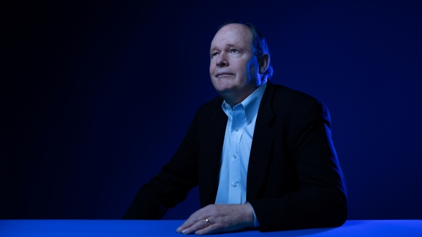 Portrait of professor sitting at desk with blue lighting