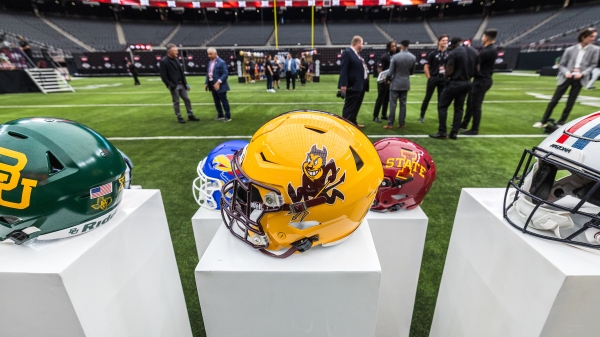 ASU football helmet sits on a pedestal with other Big 12 helmets on a football field