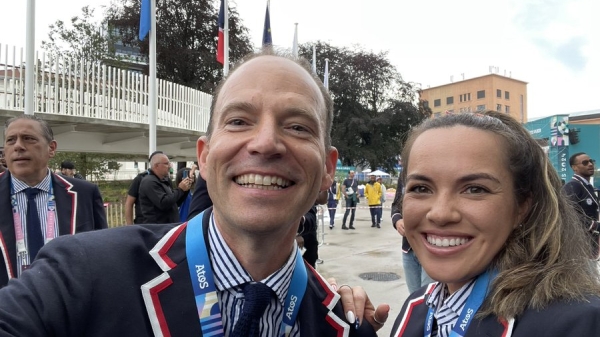 Two people in blazers smile for the camera.