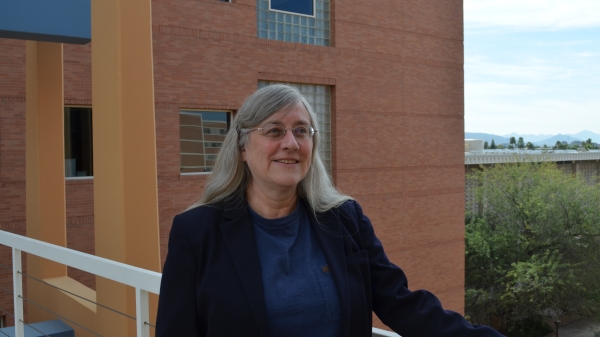 Photo of a woman standing in front of a brick building