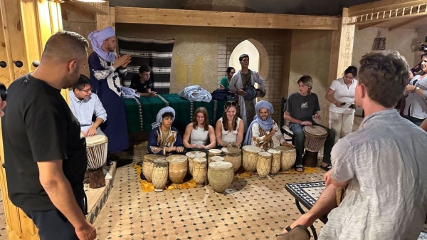 Moroccan hotel staff and ASU students playing instruments.