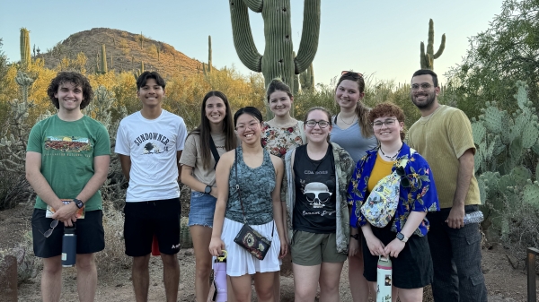 Group of students pose for a photo in a desert landscape.