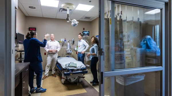 Four people standing around an emergency room bed.